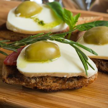 Bruschetta with tomato, mozarella and olive on wooden table 