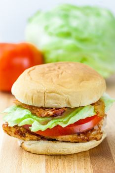 Grilled chicken breast with lettuce, tomato, bacon, and ranch dressing on a fresh roll.