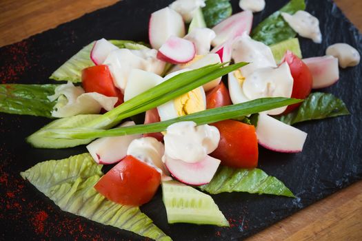 Summer salad of tomatoes, cucumbers, asparagus, young green peas dressed with olive oil and watercress salad