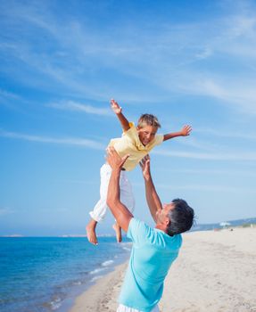 Father and son playing at the beach in the day time