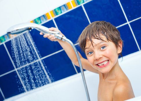 Close-up portrait of cute little boy in bathroom with shower