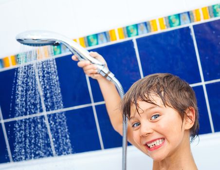 Close-up portrait of cute little boy in bathroom with shower