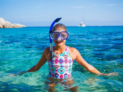 Happy cute girl wearing snorkeling mask ready to dive in the sea