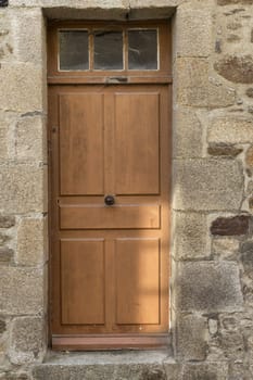 A single brown door in with a knob in the middle