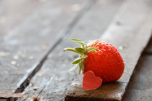 Valentine background: heart  and strawberries on wooden background