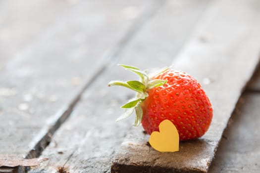 Valentine background: heart  and strawberries on wooden background