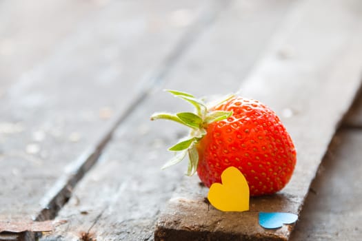 Valentine background: heart  and strawberries on wooden background