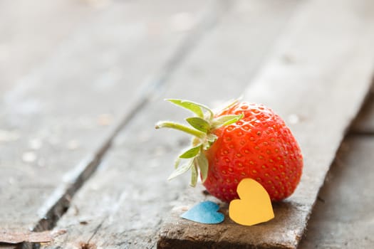 Valentine background: heart  and strawberries on wooden background