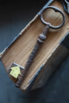 Key of house. Vintage key, old book and paper house.