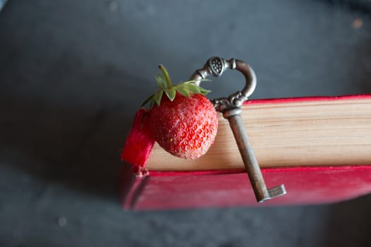 Strawberries and antique key on a red cook book