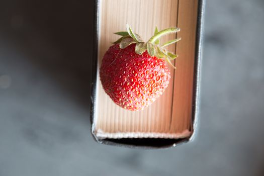 Strawberries and  cook book on a dark table. Healthy Eating.