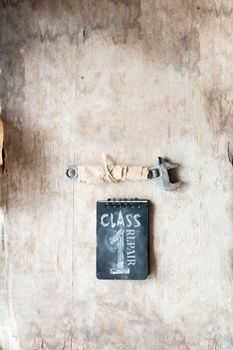 Repair concept. Inscription repair, first class and a wrench on a wooden table workshop.