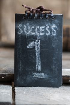 Success, first concept, chalk inscription and wooden table.