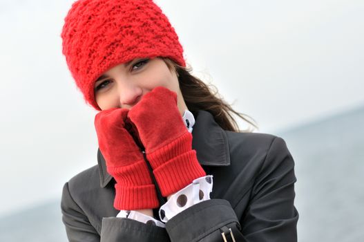 girl wearing  reg hat and red gloves outdors