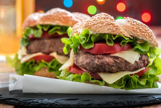 Closeup of Homemade Hamburger with Fresh Vegetables and Lights in Background