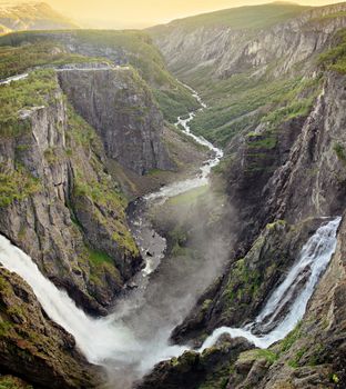 The big waterfall Voringsfossen with its 182 meter fall cascading into Mabodalen valley in Eidfjord, Hordaland, Norway at sunset.
