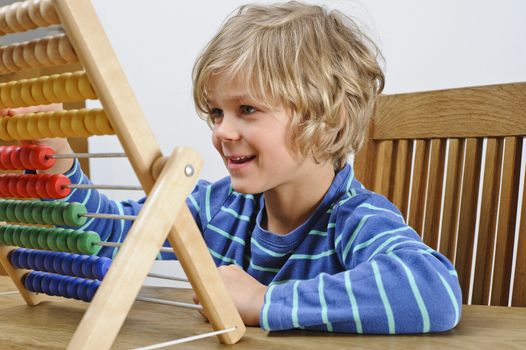 A young boy learns to count using an abacus