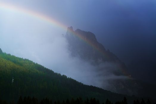 rainbow over the mountains during a thunderstorm in a summer sunset, San Martino di Castrozza - Trentino, Italy