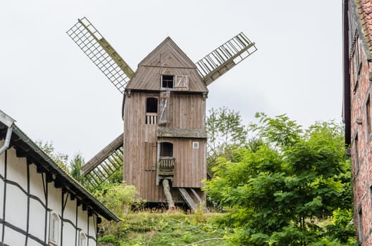 The windmill of Dutch design behind a half-timbered house.