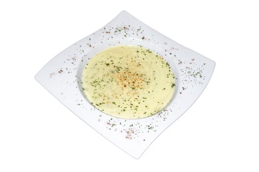 White plate filled with broccoli vegetable soup on white background.