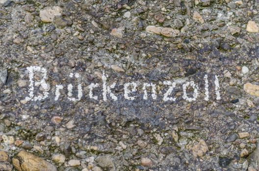 Concrete wall with inscription in white bridge toll