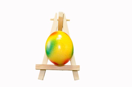Easter is on artist easel. Easter egg painting.