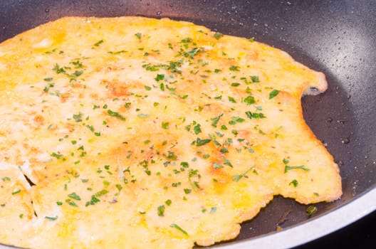 Freshly cooked omelet, pancake in a frying pan.