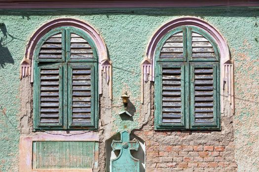 Brasov, Romania - June 9, 2013: Green old house windows with wood curtains from Brasov, Romania