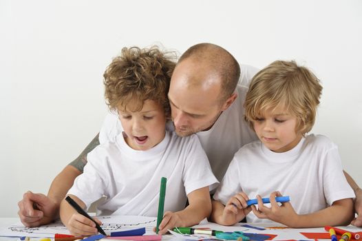 Father teaches his sons how to draw. 