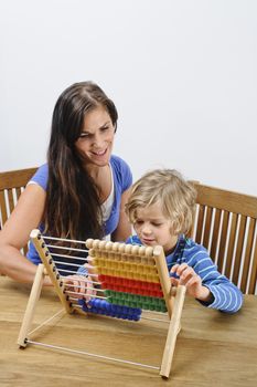 Mother teaches her son how to count using an abacus