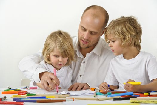 Father teaches his young son how to hold a pen