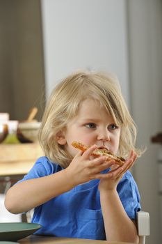 Young boy enjoys a slice of pizza
