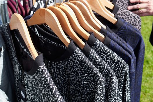 Fashionable design modern blouses on hanger rack display in a store                               