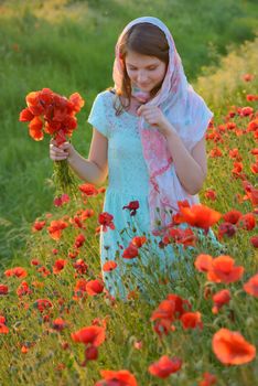 girl  in field of poppies in summer sunset