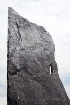 rock head stone from a grave yard in ireland with sun and cloudy background