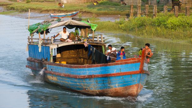 Sittwe, Rakhine State, Myanmar - October 16, 2014: Cargo vessel navigating a canal near Sittwe, the capital of the Rakhine State in Myanmar.