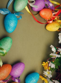 Easter flower arrangement and colorful eggs on green background with space for text