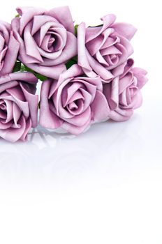 artificial bouquet of purple roses on a white background