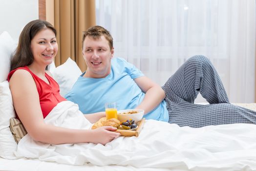 a married couple together breakfast in bed