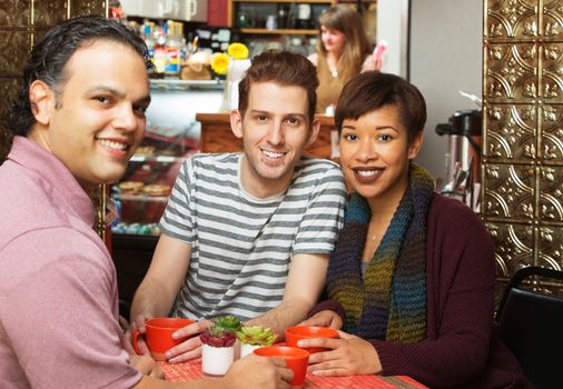 Three young adults at coffee house indoors