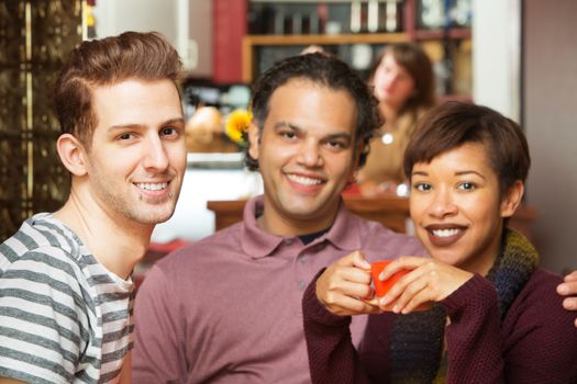 Handsome trio of adults having coffee at bistro