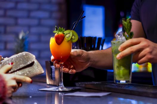 Barmen Serving Cocktails While Woman Waits with a Wallet