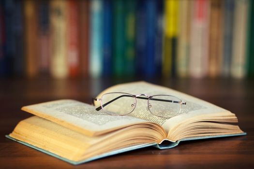 glasses and book on background bookcase