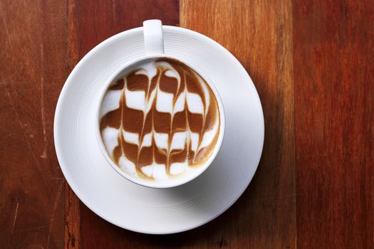 Cup of latte coffee on the wooden desk