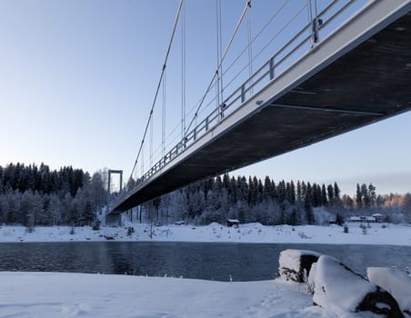 A bridge in a winter landscape from beneath with a river