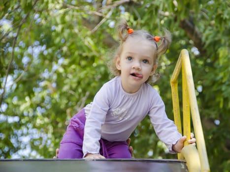 The little girl climbed the hill, the girl stuck her tongue out