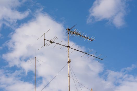 Distant view of a television antenna on a house's rooftop.