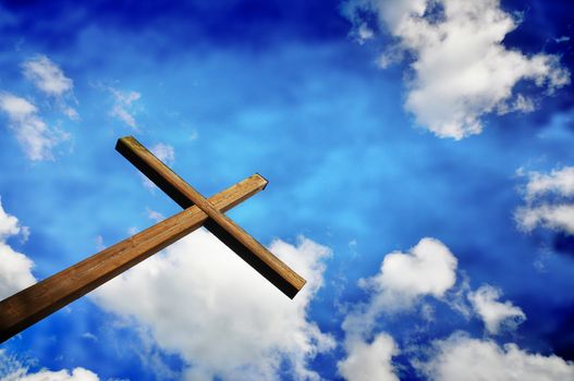 Dreamy softly textured image of cross aganst blue sky
