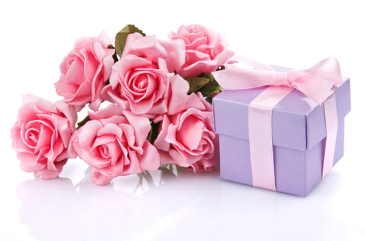 pink flowers and purple gift box with pink ribbon and bow on a white background
