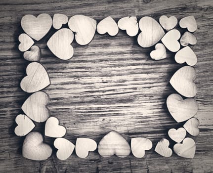 Valentines day frame with hearts on a wooden background, white and black